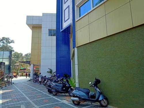 a row of scooters parked next to a building at Anchani Residency Rooms in Pāmbādi