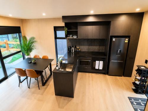 a kitchen with a black refrigerator and a table with chairs at Relax on Remarkable in Queenstown