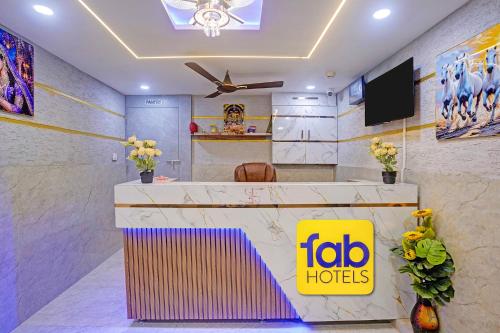 a lobby of a hotel with a tv and a reception desk at FabHotel Sky Inn I in Ahmedabad
