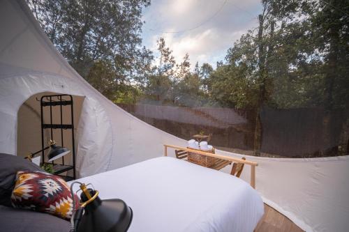 a white tent with a bed and a window at Burbujas cerca de Ronda in Ronda