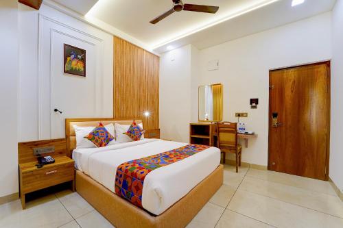 a bedroom with a bed and a table and a desk at FabHotel Prime Hash Four in Ernakulam