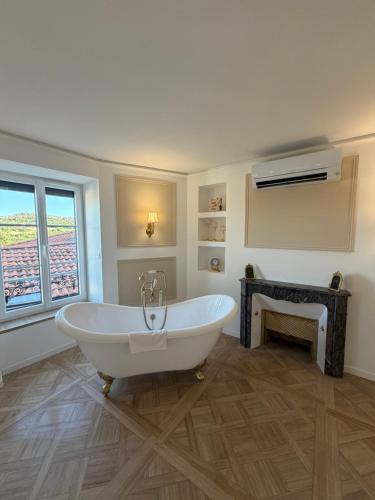 a white bath tub in a bathroom with a window at Suite Lisa in La Roche-Blanche
