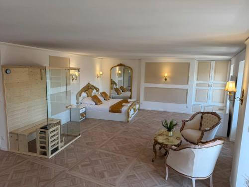 a bedroom with a bed and a couch and a chair at Suite Lisa in La Roche-Blanche