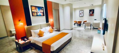 a hotel room with a bed and a dining room at Ira By Orchid Bhavnagar in Bhavnagar