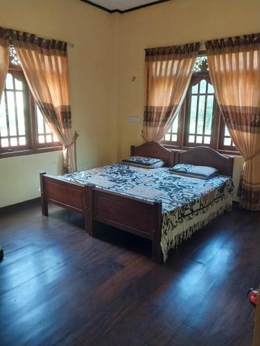 a bedroom with a large bed in a room with windows at Miriswaththa resort in Deniyaya