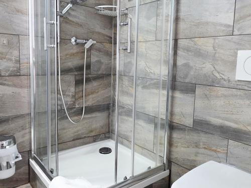 a shower with a glass door in a bathroom at Pension La Casa in Radolfzell am Bodensee
