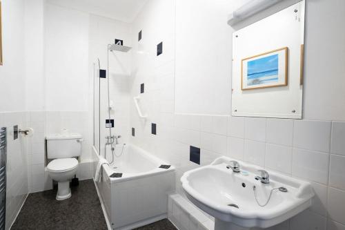a white bathroom with a sink and a toilet at Bowood Park Hotel in Camelford