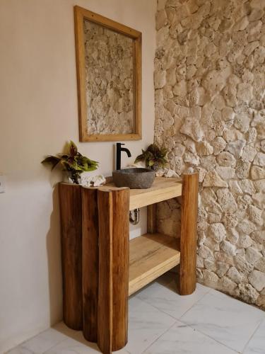 a bathroom with a sink and a stone wall at Simagirau Homestay in Simpatdegat