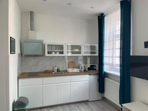 a kitchen with white cabinets and a counter top at Apartman cheb in Cheb