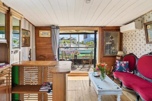 a living room with a table and chairs and a view of the ocean at Superbe Péniche En Centre Ville in Bordeaux