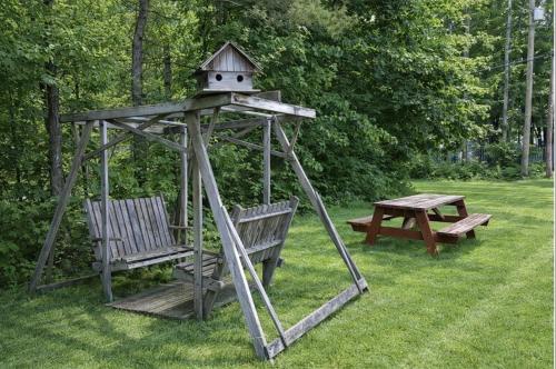 two benches and a bird house and a picnic table at GAGE FARMHOUSE LIMIT 6 apts in Bridgton