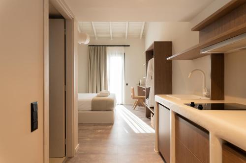 a kitchen with a sink and a bedroom with a bed at Ichos Boutique Apartments in Volissos