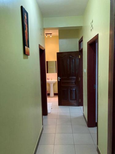 a hallway with two doors and a bathroom with a sink at sunset suswa apartment in Mombasa