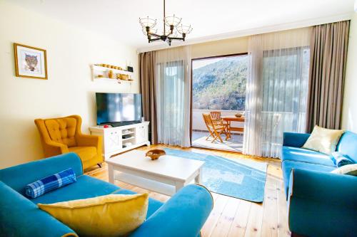 a living room with blue couches and a table at Paradise House Skadar Lake in Karuč