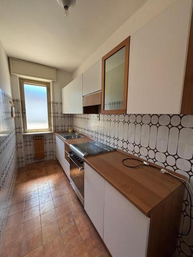 a kitchen with white cabinets and a counter top at Vecchio Mulino-Via Barale 40 in Entracque