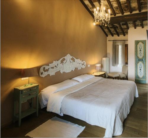 a bedroom with a large bed and a chandelier at Casa Mia A Cortona in Cortona