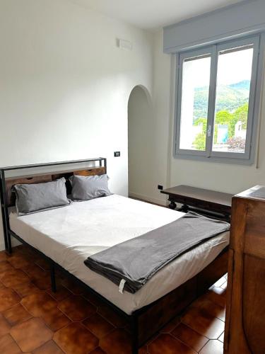 a large bed in a room with a window at Smart Living Tavernerio in Tavernerio