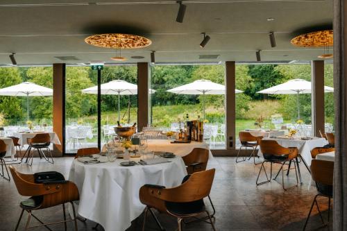 a dining room with tables and chairs and umbrellas at Hotel Winselerhof by Flow in Landgraaf