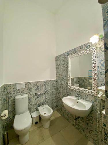 a bathroom with a toilet and a sink and a mirror at Tenuta Arangio Agriturismo Vendicari in Casa Maccari
