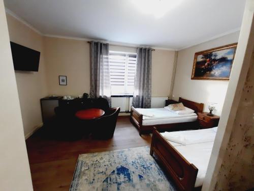 a living room with two beds and a couch at Hotel i Apartamenty Rosa in Przemyśl