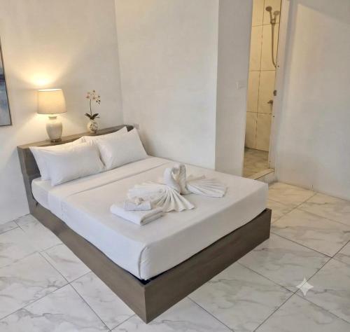a white bed with a towel on it in a room at SET Inn-2 in Kata Beach