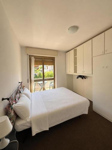 a bedroom with a white bed and a window at Vecchio Mulino-Via Barale 40 in Entracque