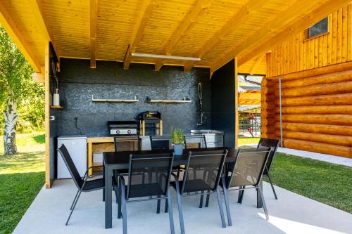 a patio with a table and chairs and a kitchen at Villa Harmonia Private Jacuzzi and Pool Retreat near Rogaška in Rogatec