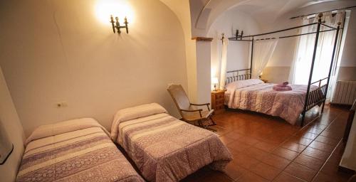 a room with two beds and a chair in it at La Casa de los Templarios in Puebla de Alcocer
