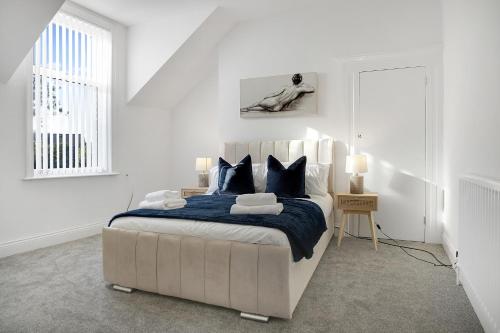 a white bedroom with a bed and a window at Spacious 4BR retreat Eden Vale by Stay With Us in Sunderland