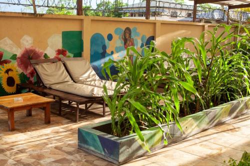 a bench in a courtyard with plants and a mural at Barolena Hotel en appartement in Paramaribo