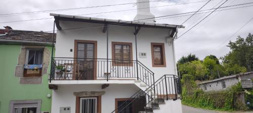 a white house with a balcony on it at O retiro da Trabe in Viveiro