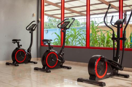 three exercise bikes in a room with a window at Barolena Hotel en appartement in Paramaribo