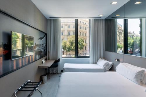 a hotel room with two beds and a window at Negresco Princess 4* Sup in Barcelona