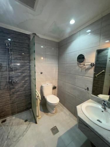 a bathroom with a toilet and a sink and a shower at فندق شعاع النزهة - مكة المكرمة in Mecca