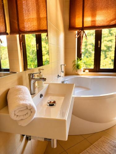 a bathroom with a tub and a sink with a towel at Pensjonat Pod Jemiołą in Ciechocinek