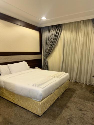 a bedroom with a large bed in front of a window at فندق شعاع النزهة - مكة المكرمة in Mecca