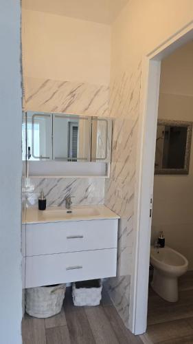 a white bathroom with a sink and a toilet at Bella Vita Stays Wellness in Sondrio