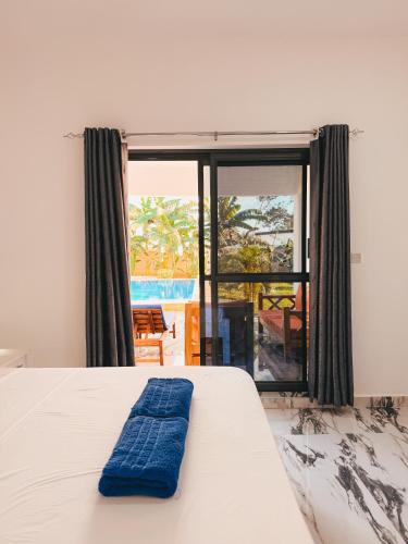a bedroom with a bed with a blue towel on it at Diani Dream luxury apartment in Diani Beach