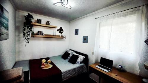 a bedroom with a bed and a desk and a laptop at Montebar1 in Bar