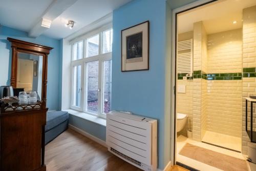 a bathroom with a walk in shower next to a window at Hotel Bet van Beeren in Amsterdam