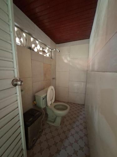 a bathroom with a green toilet in a room at Hostal Puerto del Reino in Puerto Colombia