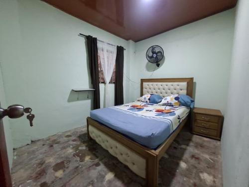 a bedroom with a bed with a blue comforter at Hostal Puerto del Reino in Puerto Colombia