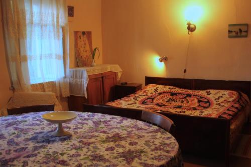 a small room with a bed and a table with a table at Lilac Orbeti - Cool Climate Country House Near Tbilisi in Pantiani