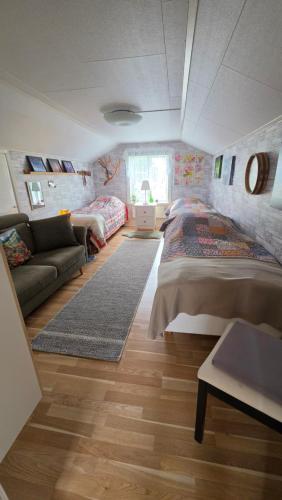 a bedroom with a large bed and a couch at Kolmårdstorpet Blomsätter in Kolmården