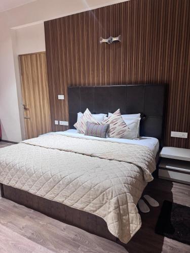 a bedroom with a large bed with a black headboard at Rare Aura Villa in Dod Jāla