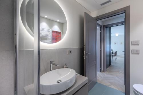 a bathroom with a white sink and a mirror at Dune Luxury Residence in Turin