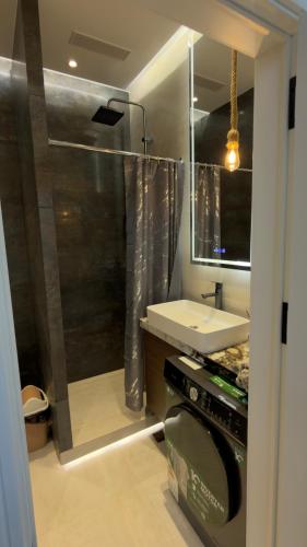 a bathroom with a shower and a white sink at Apt Elite in Khujand