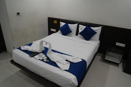 a bedroom with a bed with swans on it at Hotel Laasya Grand in Vijayawāda