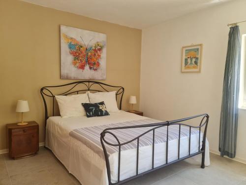 a bedroom with a bed with a butterfly painting on the wall at Apartment Stiniva in Hvar