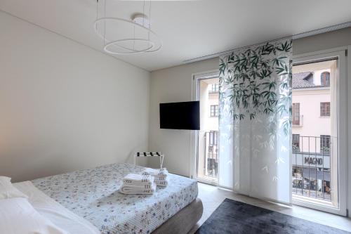 a white bedroom with a bed and a window at Dune Luxury Residence in Turin